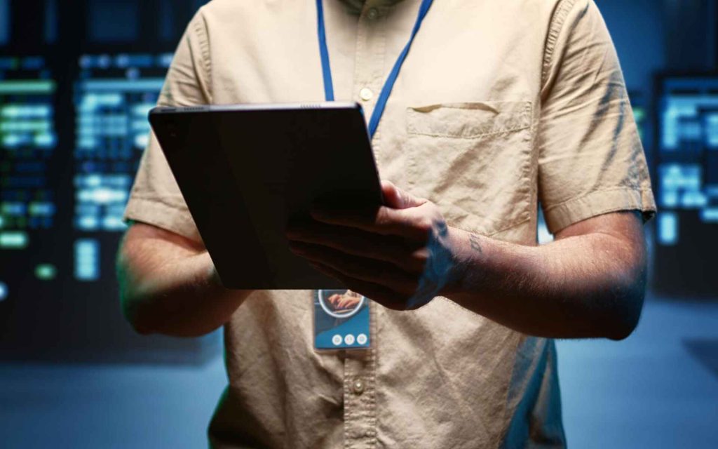 IT professional reviewing security controls in a data centre as part of ISO 27001 continuous improvement.